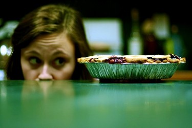 женщина искоса смотрит на полную тарелку с едой