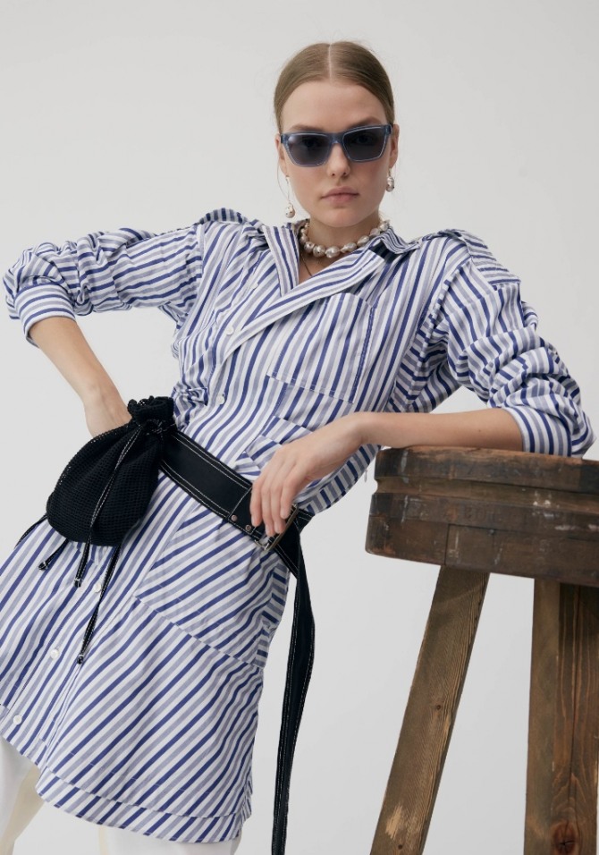 деловое платье на летний сезон 2019 в полоску поверх брюк м укороченными рукавами на манжете и отложным воротником, круглые бусы, поясная сумка на широком черном ремне