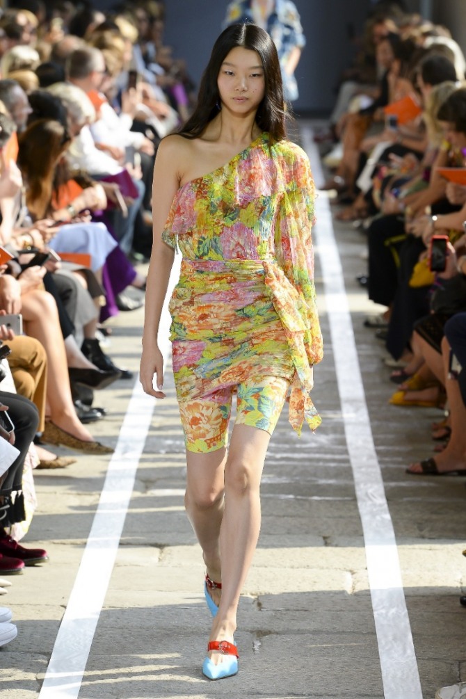 летняя уличная мода 2019 - пестрое с поясом обтягивающее мини платье из шифона на одно плечо поверх коротких лосин
