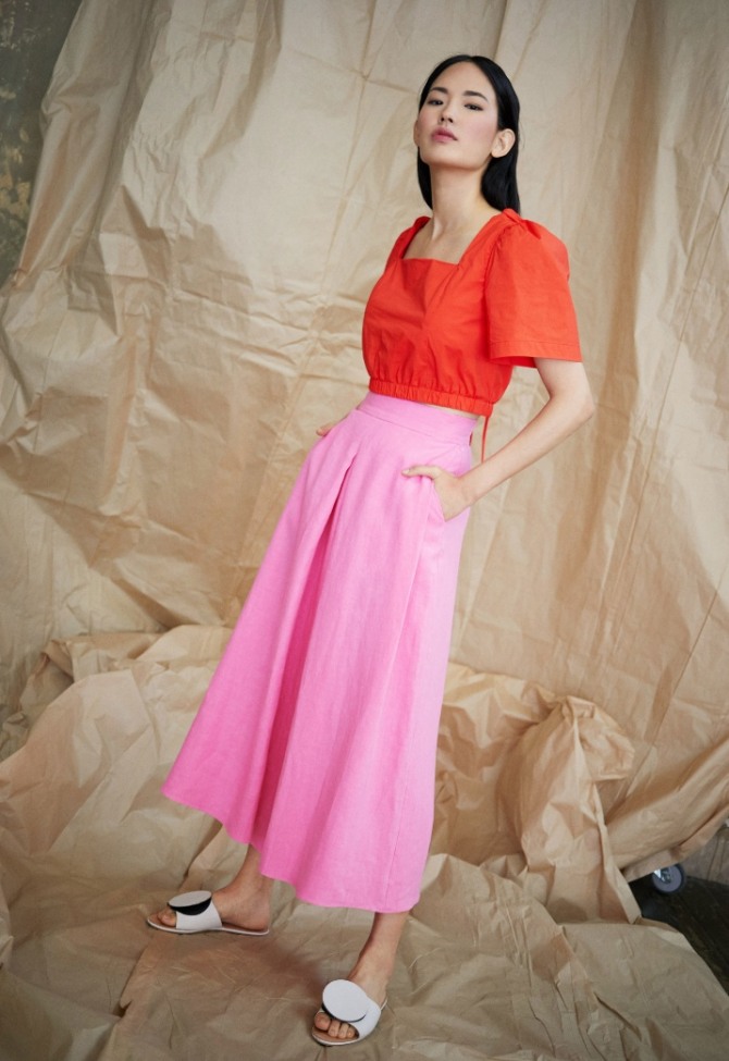 красная короткая блузка поверх длинной розовой юбки