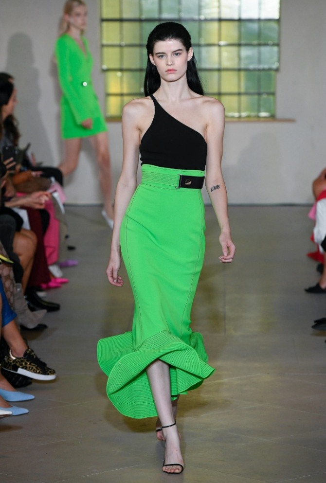 ядовито-зеленая юбка с воланом по подолу и с черным асимметричным топом на одно плечо