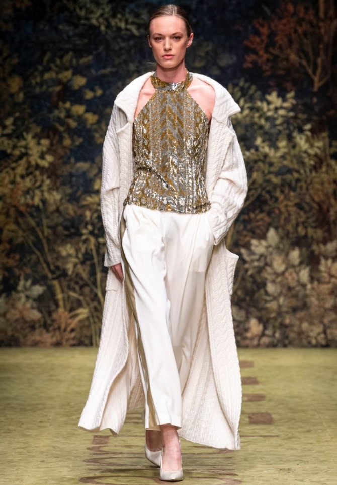 длинное белое трикотажное пальто с имитацией ручной вязки поверх белестящего топа с американской проймой и элегантных белых брюк - вечерний образ осени 2020