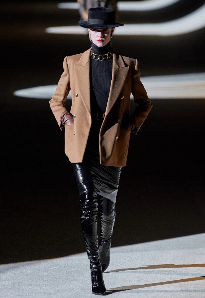 образ от Saint Laurent осень-зима 2020-2021 с женским пиджаком бежевого цвета - черная шляпа, черный низ и нижний слой, колье в виде колец из металла желтого цвета