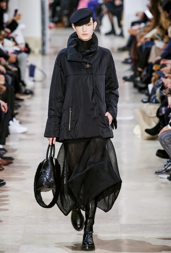 модный демисезонные уличный образ 2021 года в стиле тотал-блэк - женская куртка из нейлона, прозрачная юбка, грубые сапоги и шерстяная кепка