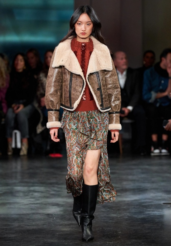 куртка-пропитка с модных показов на 2021 год - женская модель коричневой глянцевой куртки с большим меховым светлым воротником от бренда Veronica Beard