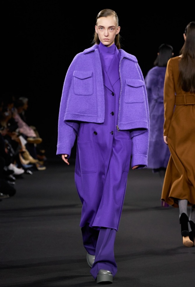короткая женская шерстяная куртка куртка с накладными карманами на груди, модель фиолетового цвета поверх плаща - тренды осень-зима 2020-2021 от бренда Rochas