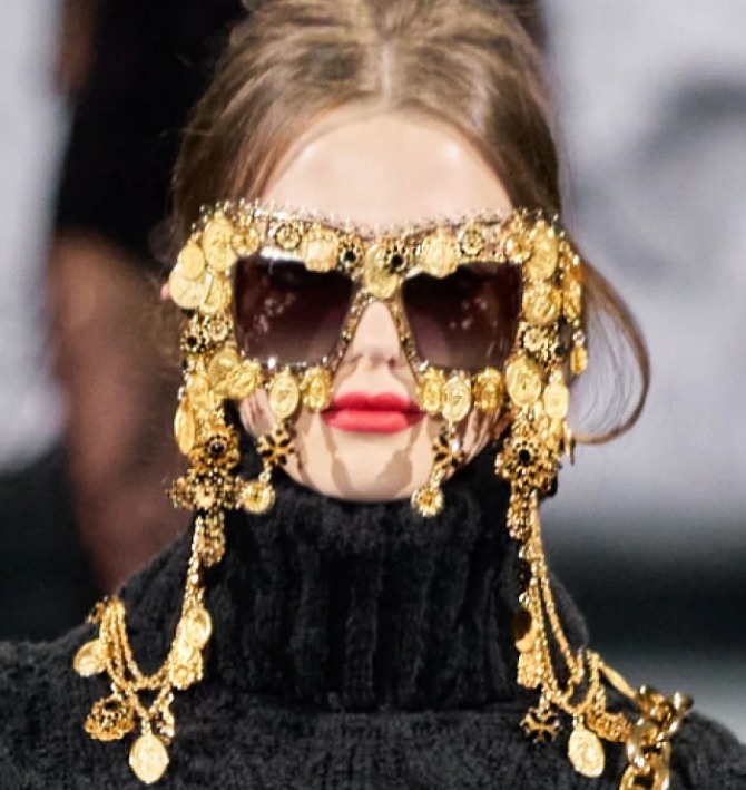 бренд Dolce & Gabbana показал очки, прикрепленные к шейной цепочке, модель полностью декорирована монистами из металла желтого цвета - подиум осень-зима 2020-2021
