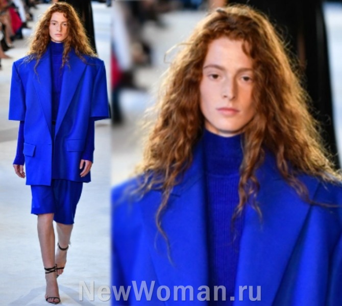 стильный аутфит - синий деловой костюм с юбкой и рыжие завитые волосы