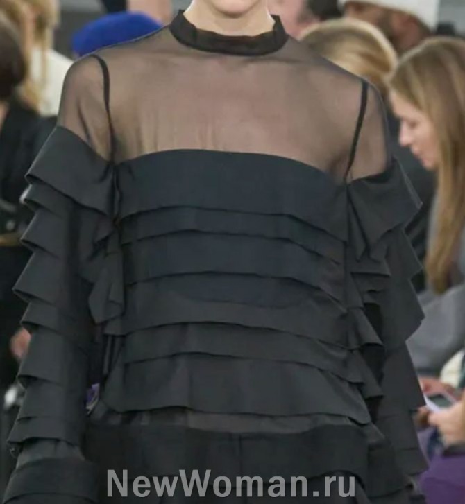 блузка черного цвета с многоярусными горизонтальными складками и прозрачным верхом - мода из Парижа на 2024 год