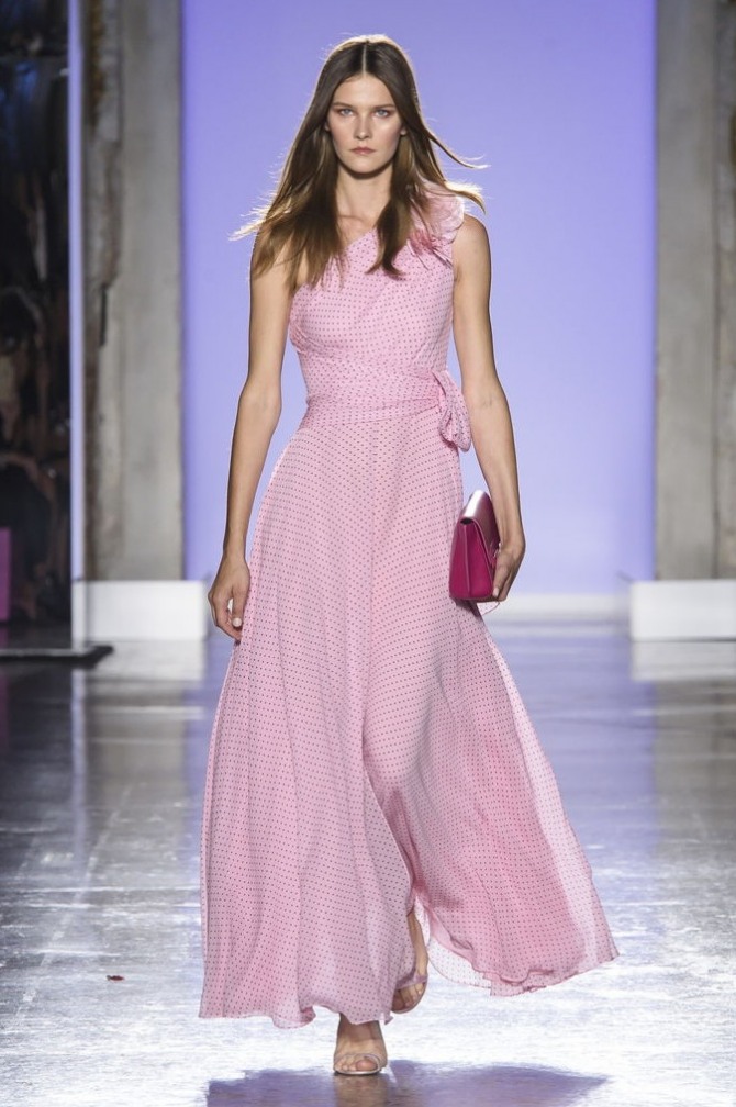 красивое нежное элегантное розовое летнее платье 2019 на одно плечо с расклешенной от талии юбкой в мелкий горох и с широким поясом с завязкой на бант, длина макси
