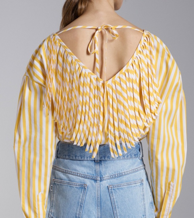 желтая блузка с вырезом на спине, оформленным бахромой из полосок ткани