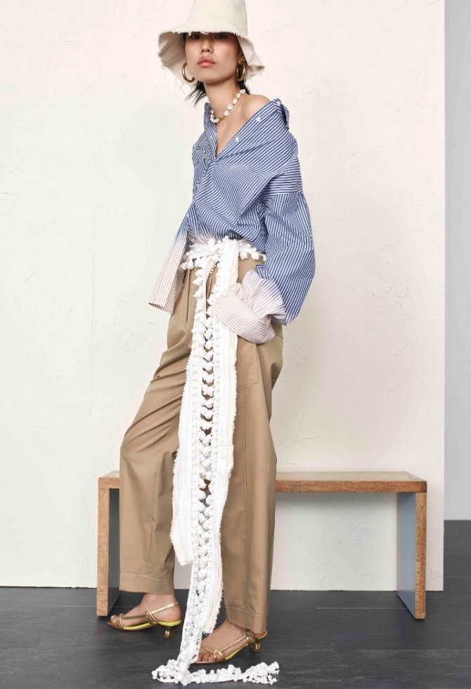 летний образ со светло-коричневыми брюками, блузкой-рубашкой в бело-синию полоску на одно плечо и длинным белым вязаным поясом