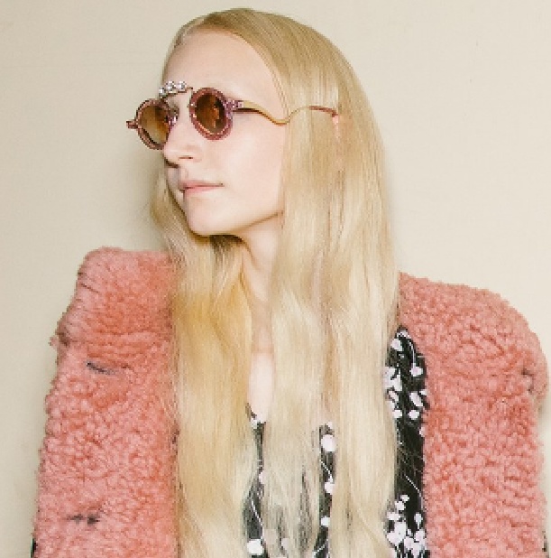 блондинка с длинными волосами в дубленке с розовой овчиной и круглыми ретро-очками