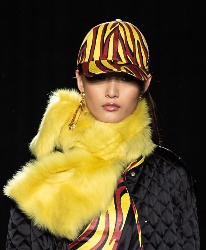 яркая полосатая кепка в комплекте с ярко-желтым меховым палантином от Versace