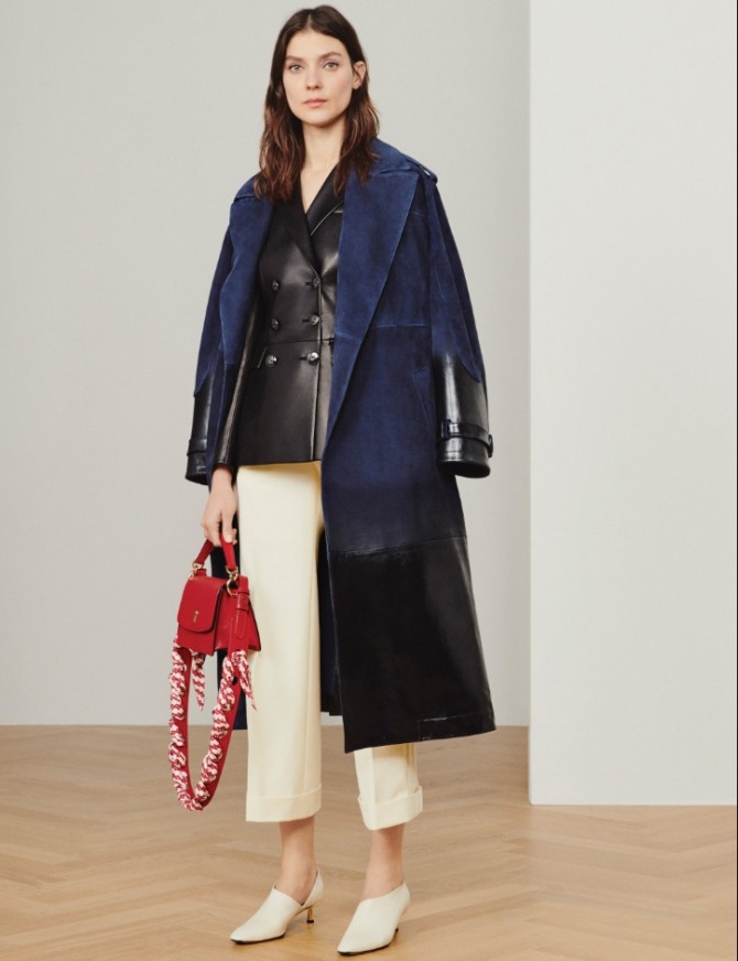 идея стильного образа с сине-черным комбинированным пальто из замши и кожи от бренда Bally на весенний сезон 2020 года, с красной сумкой, белыми прямыми обычными брюками и мюлями белого цвета