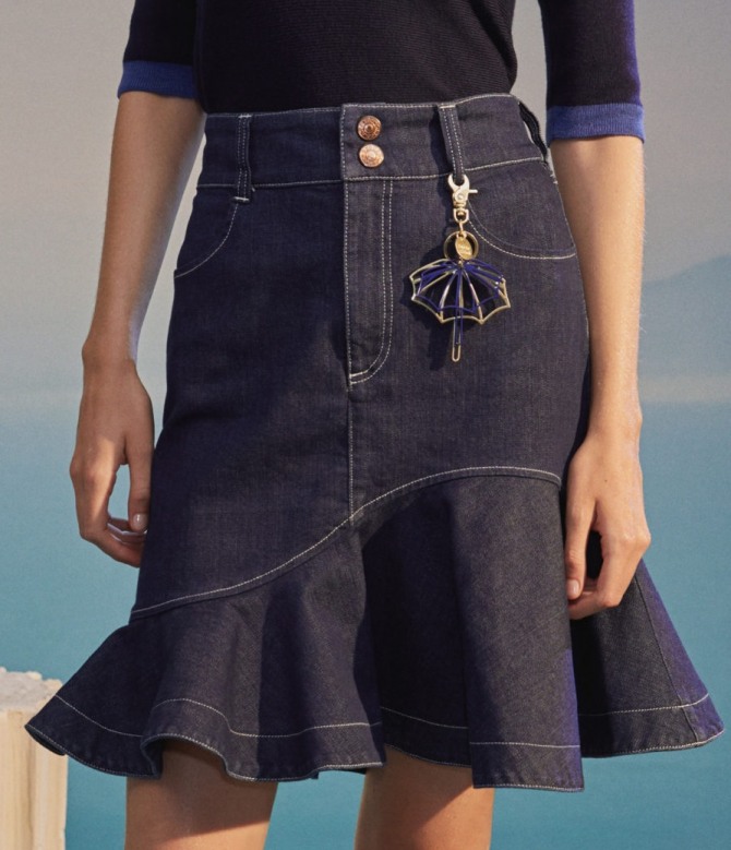 красивая молодежная джинсовая летняя юбка для девушки с отрезным волнистым воланом и брелоком на поясе - тренды от мировых стилистов на сезон весна-лето 2020