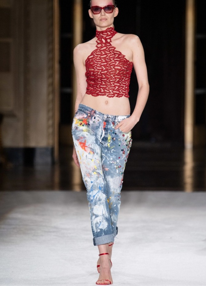 красный топ с американской проймой в комплекте с модными женскими джинсами в ярких пятнах - фото с модного показа летних образов 2020 года от бренда Christian Siriano
