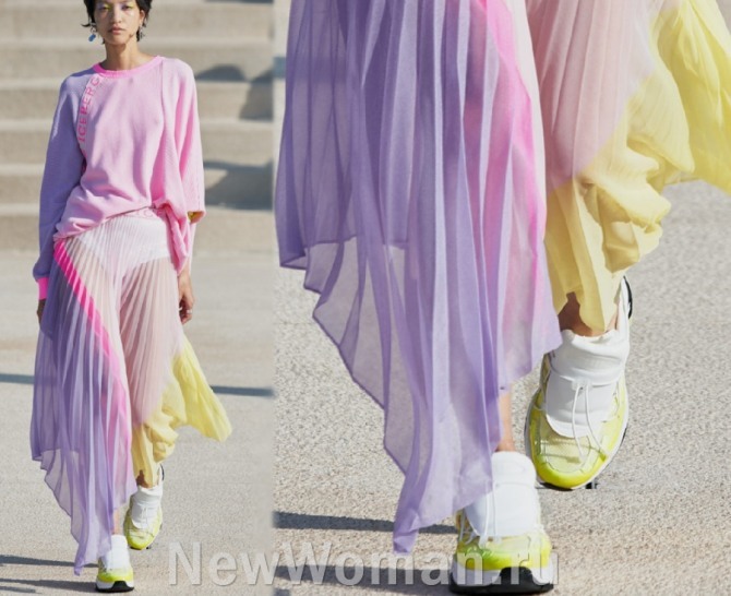 сочетание спортивного и романтического стилей - нежная летняя многоцветная зефирная юбка с неровными краями в комплекте с кроссовками и тонким летним джемпером - модный тренд летней моды 2020