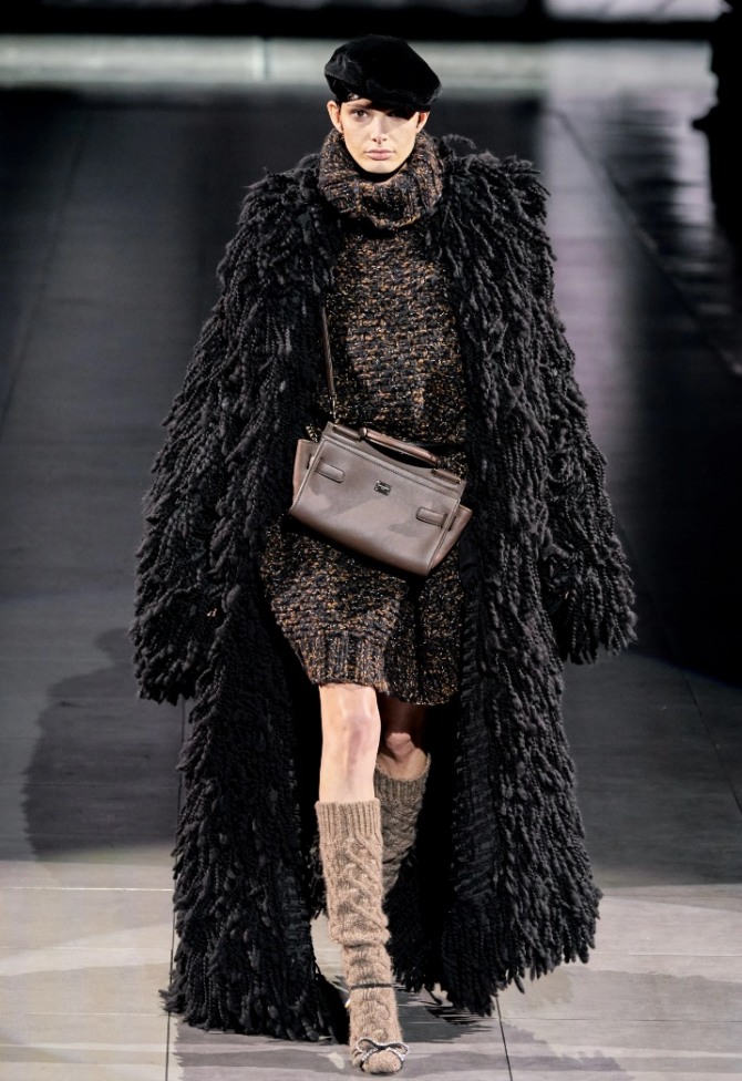 стильный модный зимний образ 2021 года - длинная черная шуба "шкура медведя" в ансамбле с платьем-свитером и черной кепкой