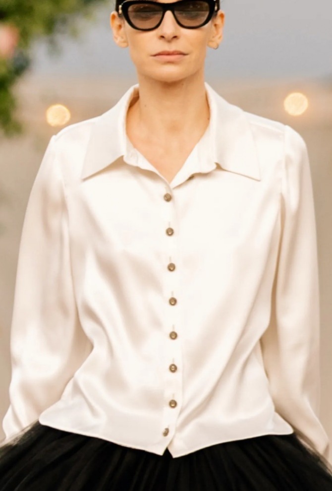 шелковая блуза жемчужного цвета от Chanel в ансамбле с пышной черной многоярусной юбкой из сетки