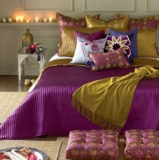 красивое сочетание цветов на многочисленных подушках и покрывале кровати в спальне в восточном стиле