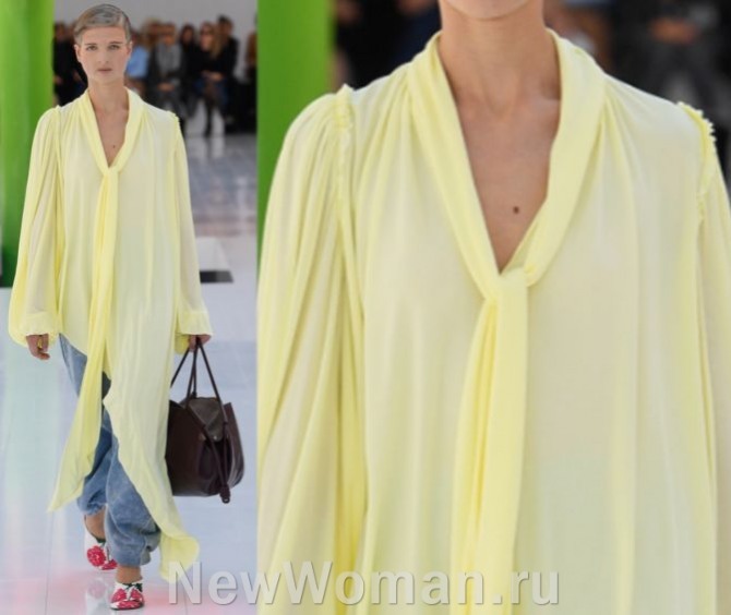 летняя мода для пожилых женщин 2023 года - длинное шифоновое желтое платье со скошенным подолом в сочетании с джинсовыми брюками