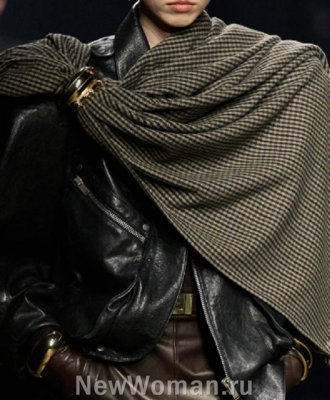 элегантная женская мода 2024 года - черная кожаная куртка-косуха, декорированная шалью с клетчатым принтом виши, драпировка закреплена брошью из множества крупных колец