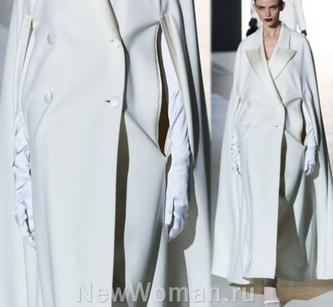 главные тенденции в моде на женские пальто 2024 года - белое длинное расклешенное пальто-кейп с прорезями для рук