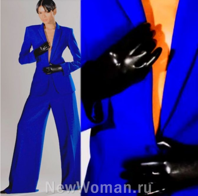 женский брючный костюм сезона осень-зима 2024, цвет электрик, жакет с широкими плечами, с глубоким вырезом горловины, сильно приталенный, брюки широкие, черные перчатки