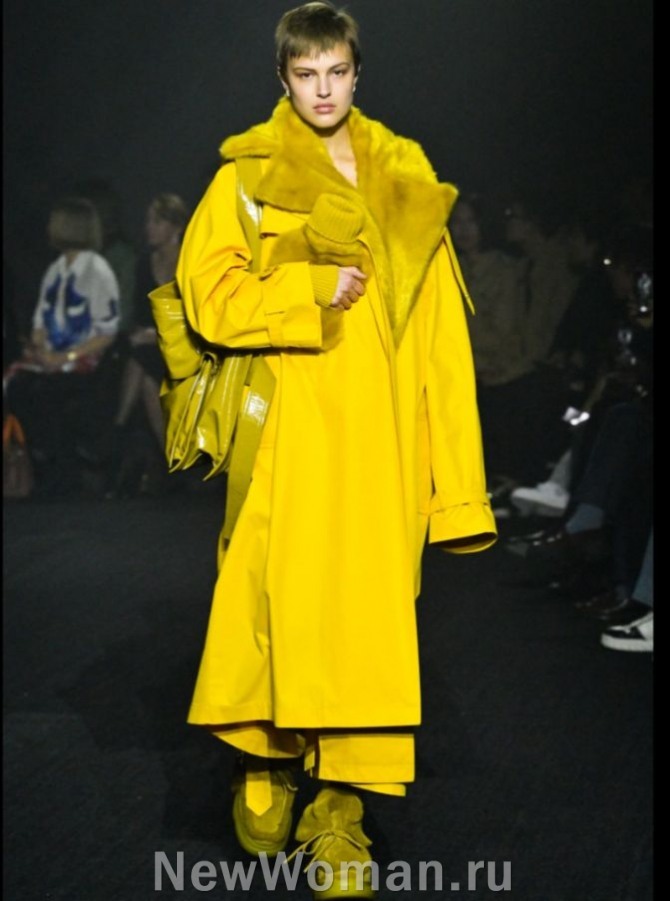 женский уличный модный образ сезона осень-зима 2024 года - желтый плащ оверсайз с меховой отделкой в сочетании с обувью и сумкой бежевого цвета