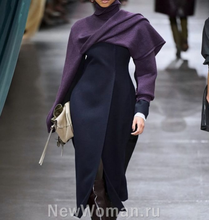 черное женское приталенное пальто с надетым поверх сиреневым свитером-трансформером-палантином с драпировкой